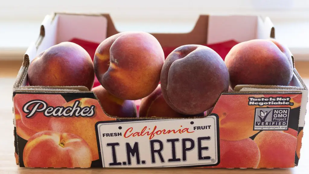 Box of ripe peaches with an I'm Ripe sign