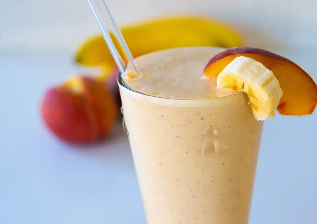 Peach Smoothie with Bananas and peaches in the background