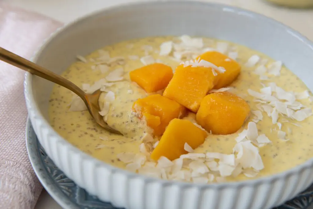 Large Bowl of Chia Pudding with Fresh Mangos and a Spoon