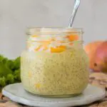 Mango Chia Pudding in a Glass jar with fresh fruit and mangoes