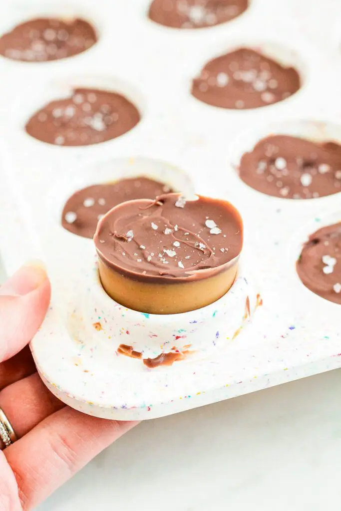 Hand lifting up a tray of healthy peanut butter cups