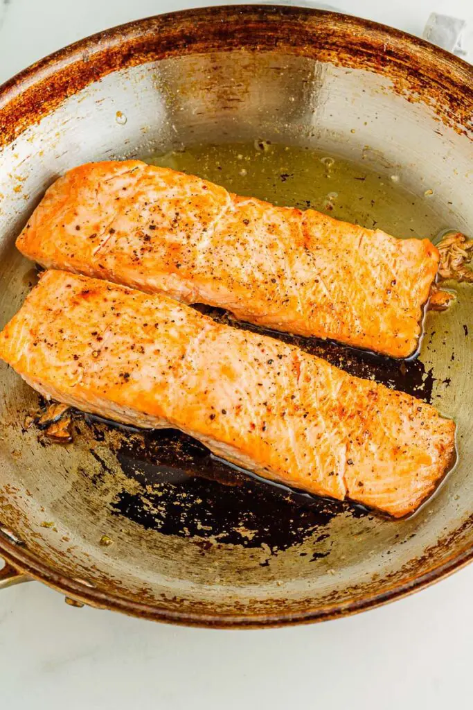 Turn salmon over in pan for salmon scampi