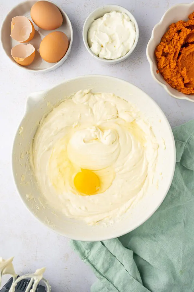 Add eggs to pumpkin cheesecake batter