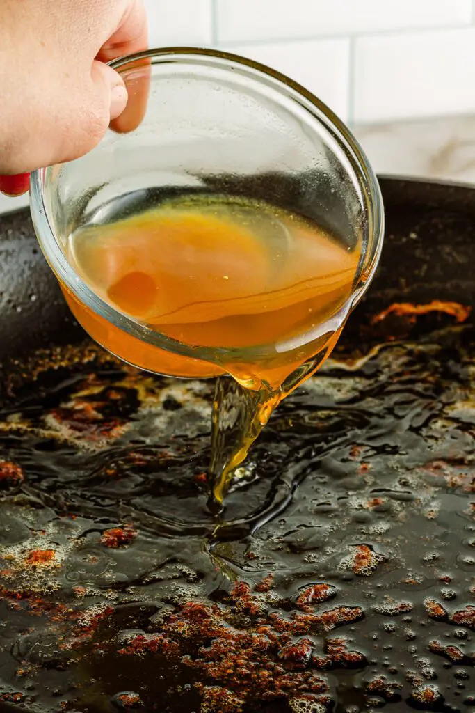 Add chicken broth to hot pan.