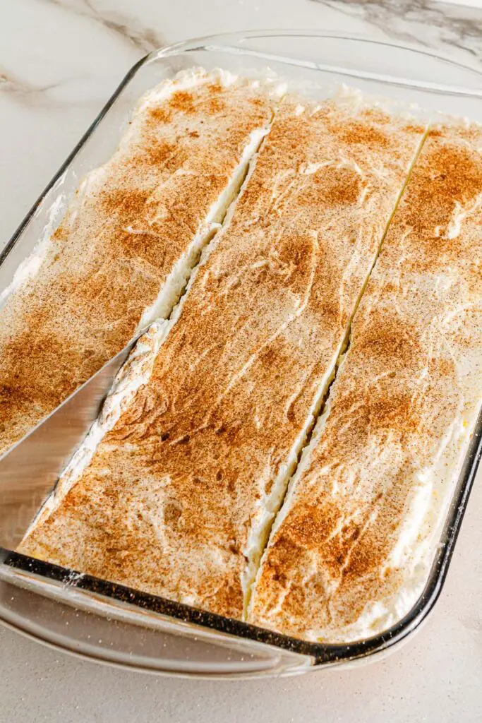 Sprinkle cinnamon on cake.