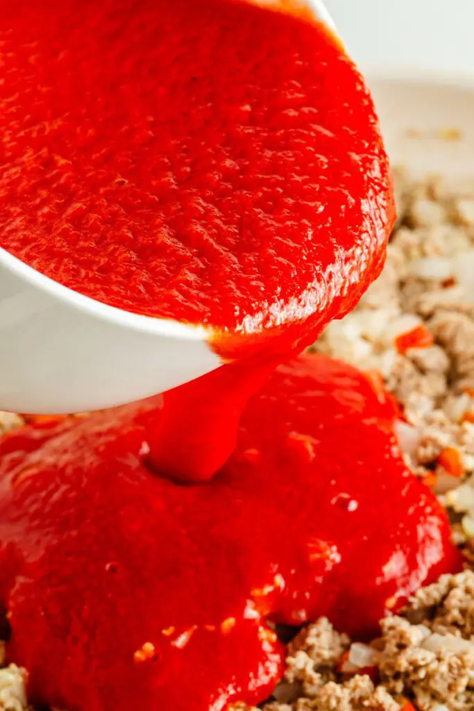 Add tomato sauce to baked gluten free pasta with turkey