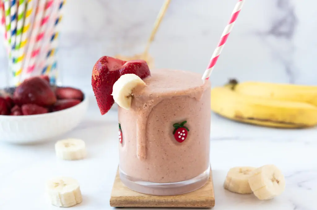 PB2 Smoothie with striped red straw and bananas and strawberries