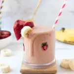PB2 Smoothie with striped red straw and bananas and strawberries