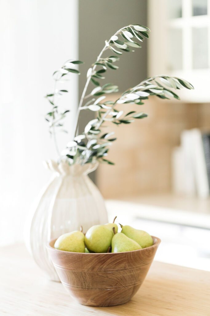 Vase of leaves and bowl of fruit 