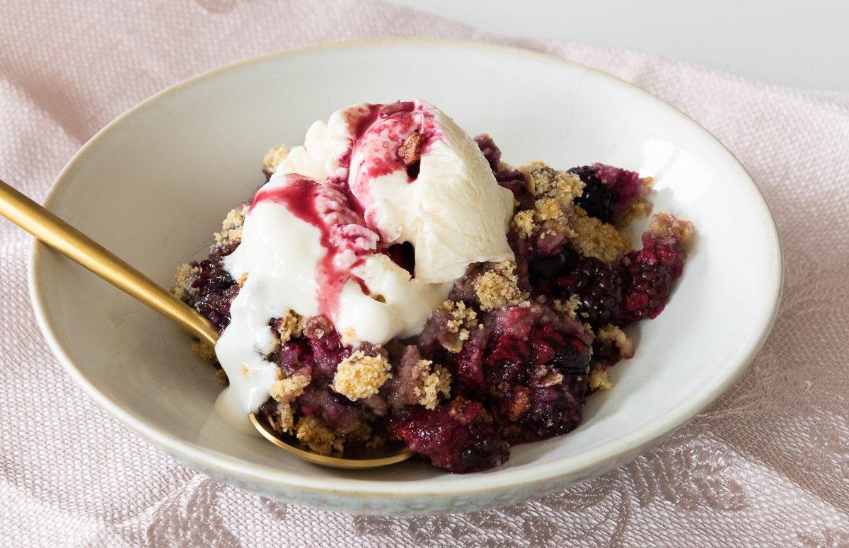 Bowl of Mixed Berry Crumble over ice cream 