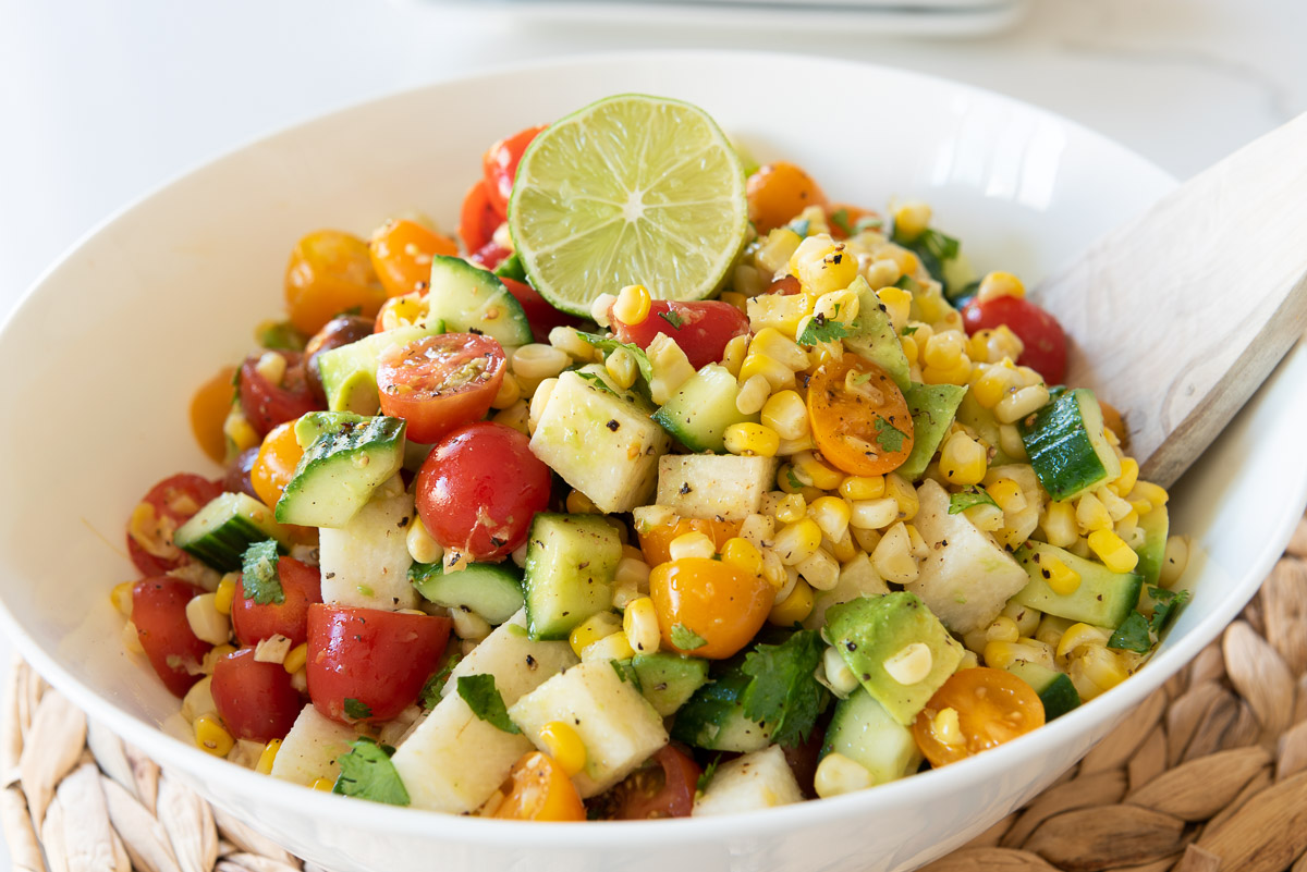 Grilled corn, avocado and lots of veggies in a white bowl