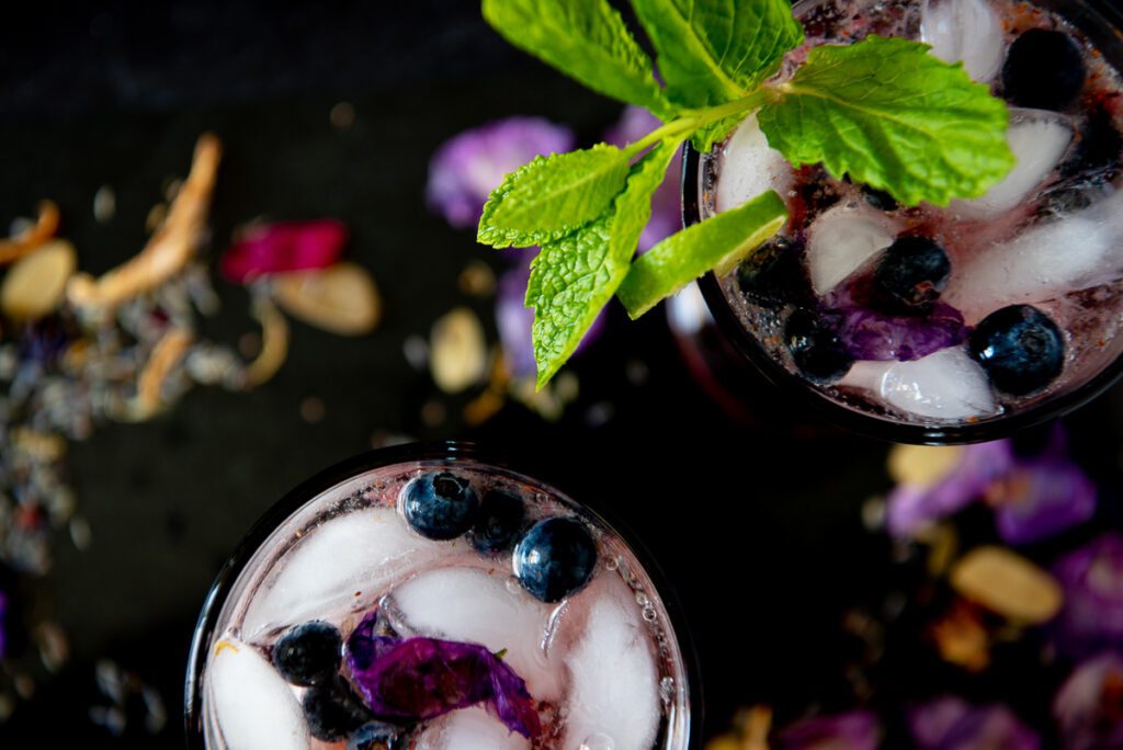 Overhead photo of glasses of blueberries, mint and lime 
