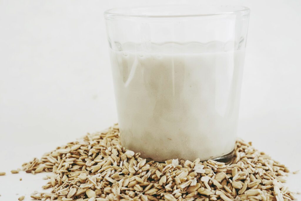 Glass of oatmilk and stack of oats 