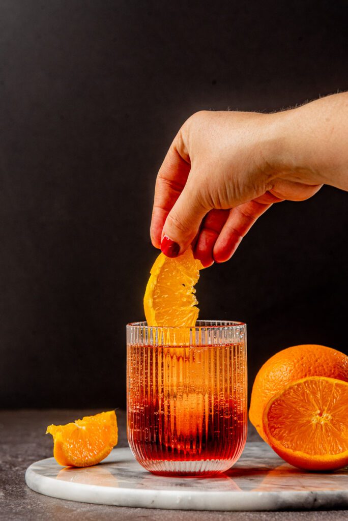 Adding oranges to a glass