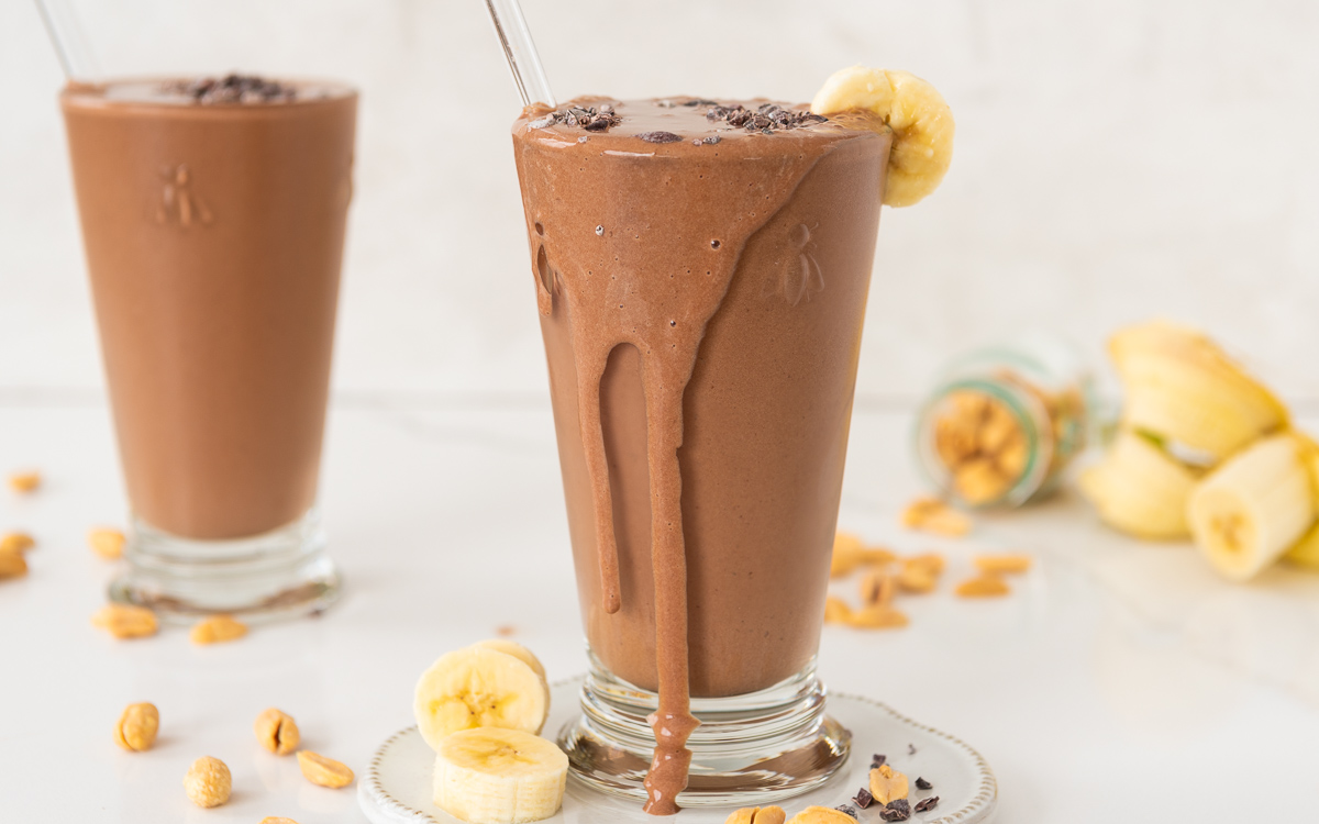 Glass of peanut butter chocolate smoothie overflowing